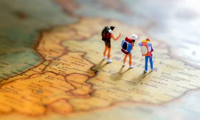 Tres muñecos sobre un mapa de sur América.Turismo Países