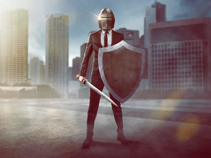 Un ejecutivo con escudo y casco que representa la defensa y seguridad
